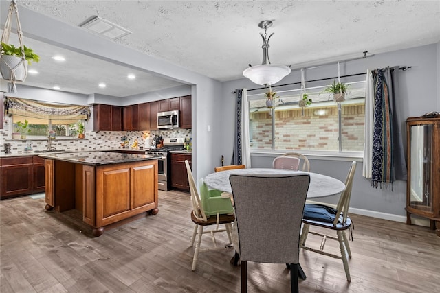 20074 Crazy Horse Circle Dr, Katy, TX 77449 - dining space with light wood-type flooring, a textured ceiling, recessed lighting, and baseboards