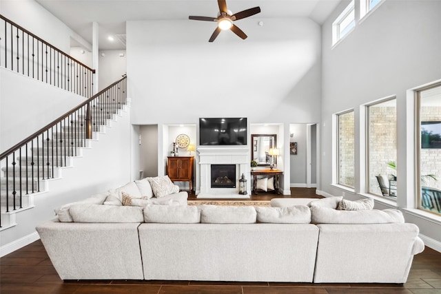 20511 Grazing Foal Ln, Tomball, TX 77377 - living room with a high ceiling, a ceiling fan, dark wood finished floors, a glass covered fireplace, and baseboards