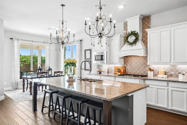 20511 Grazing Foal Ln, Tomball, TX 77377 - kitchen with a sink, stainless steel appliances, a chandelier, custom range hood, and white cabinetry
