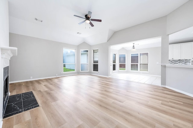 2604 Sunday House Ct, Pearland, TX 77584 - unfurnished living room featuring ceiling fan, a high end fireplace, light wood finished floors, lofted ceiling, and baseboards
