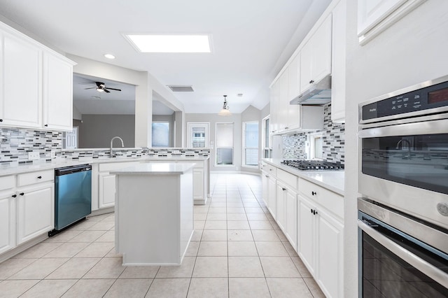 2604 Sunday House Ct, Pearland, TX 77584 - kitchen featuring appliances with stainless steel finishes, backsplash, under cabinet range hood, light tile patterned floors, and recessed lighting