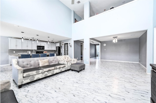 18110 Tenasserim Pine Trce, Richmond, TX 77407 - living room featuring light marble finish floors, baseboards, and a towering ceiling