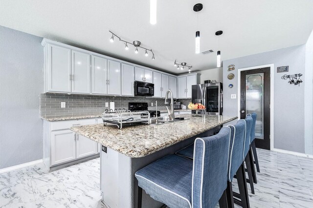 18110 Tenasserim Pine Trce, Richmond, TX 77407 - kitchen featuring black microwave, stainless steel fridge, baseboards, backsplash, and a breakfast bar area
