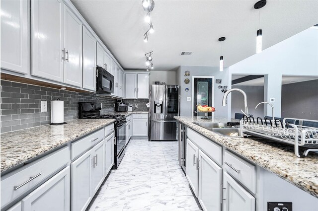 18110 Tenasserim Pine Trce, Richmond, TX 77407 - kitchen featuring black appliances, a sink, light marble finish flooring, hanging light fixtures, and backsplash