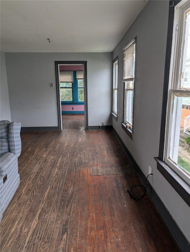 1912 52nd St, Galveston, TX 77551 - spare room featuring dark wood-type flooring, healthy amount of natural light, and baseboards