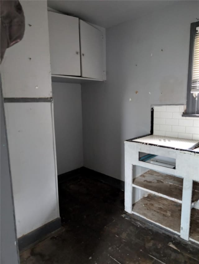1912 52nd St, Galveston, TX 77551 - kitchen featuring decorative backsplash, white cabinets, light countertops, and freestanding refrigerator