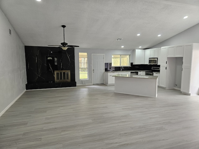 21631 Park Villa Dr, Katy, TX 77450 - unfurnished living room with a textured ceiling, a ceiling fan, light wood-style flooring, recessed lighting, and a high end fireplace