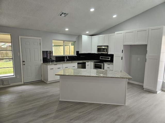 21631 Park Villa Dr, Katy, TX 77450 - kitchen with stainless steel appliances, white cabinetry, a sink, light stone counters, and a textured ceiling