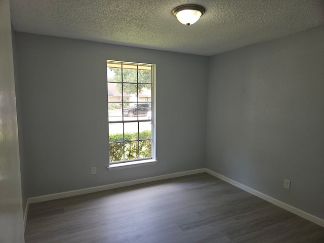 21631 Park Villa Dr, Katy, TX 77450 - spare room with dark wood-style floors, plenty of natural light, a textured ceiling, and baseboards