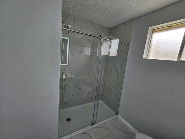 21631 Park Villa Dr, Katy, TX 77450 - bathroom featuring a marble finish shower, marble finish floors, a textured ceiling, baseboards, and toilet