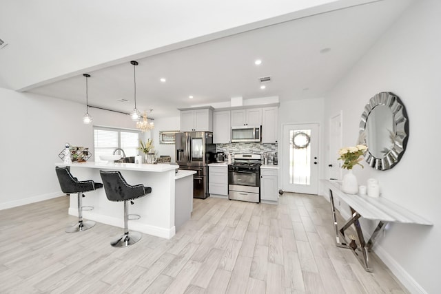 3707 Kingston Vale Dr, Houston, TX 77082 - kitchen featuring appliances with stainless steel finishes, a breakfast bar, light countertops, light wood-type flooring, and recessed lighting