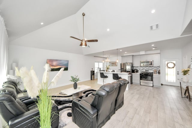 3707 Kingston Vale Dr, Houston, TX 77082 - living area with high vaulted ceiling, ceiling fan, recessed lighting, and light wood-style flooring