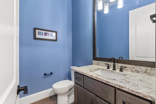 415 Faust Ln, Houston, TX 77024 - half bath featuring vanity, toilet, baseboards, and wood finished floors