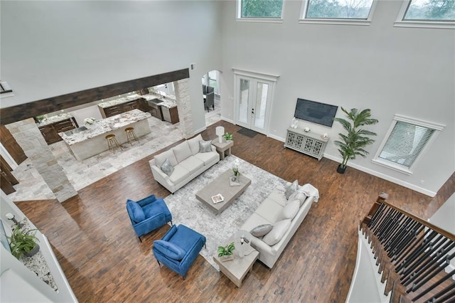 7737 Brookside Rd, Pearland, TX 77581 - living area with a high ceiling, arched walkways, baseboards, and wood finished floors