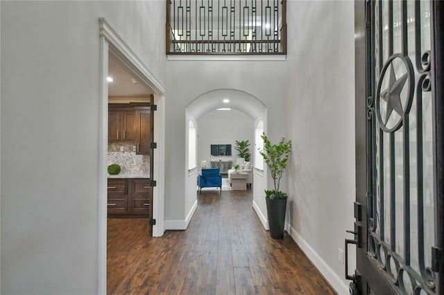 7737 Brookside Rd, Pearland, TX 77581 - foyer with arched walkways, dark wood finished floors, a high ceiling, and baseboards
