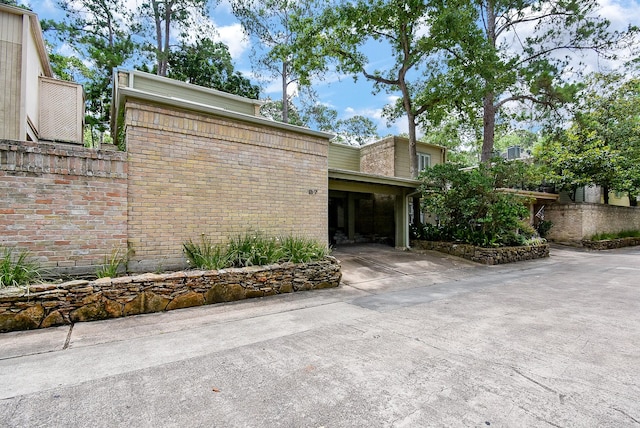 201 Vanderpool Ln Unit 27, Houston, TX 77024 - view of side of home featuring driveway and brick siding