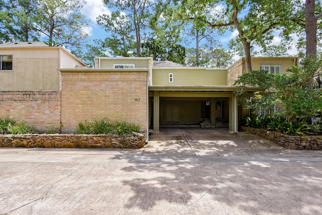 201 Vanderpool Ln Unit 27, Houston, TX 77024 - view of front of house featuring driveway, brick siding, and a carport