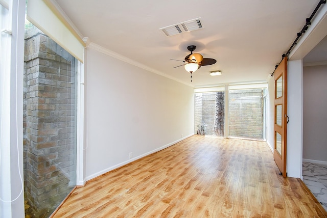201 Vanderpool Ln Unit 27, Houston, TX 77024 - unfurnished room with baseboards, a ceiling fan, wood finished floors, crown molding, and a barn door