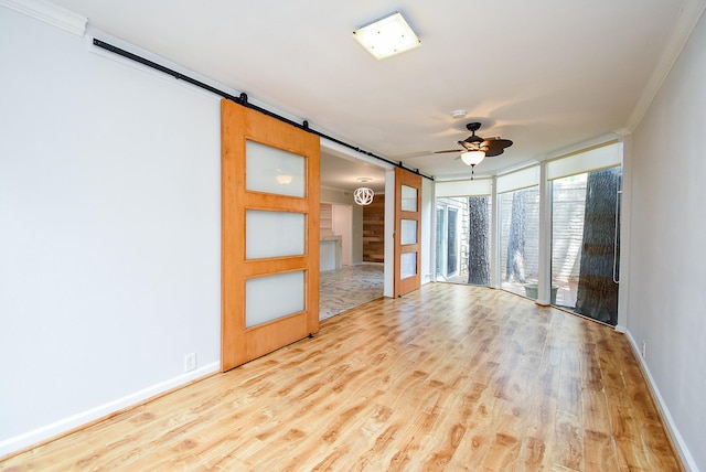 201 Vanderpool Ln Unit 27, Houston, TX 77024 - empty room with a barn door, crown molding, ceiling fan, wood finished floors, and baseboards