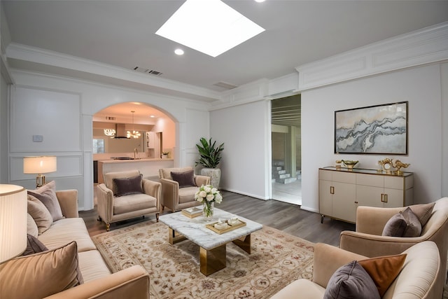 201 Vanderpool Ln Unit 27, Houston, TX 77024 - living room with dark wood-style floors, crown molding, arched walkways, recessed lighting, and a skylight