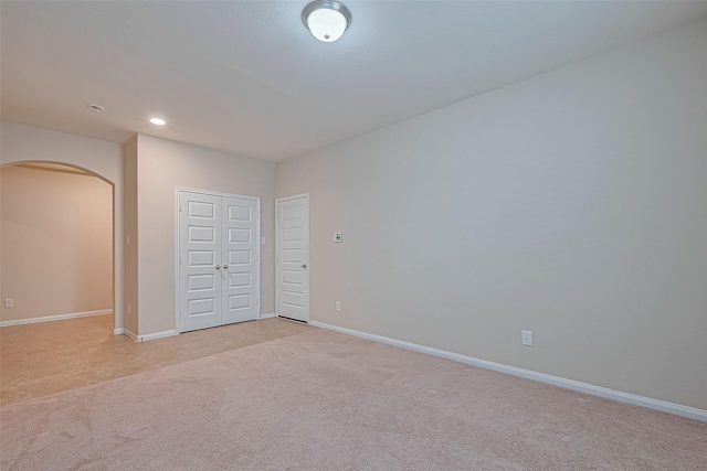13513 Palo Lake Ln, Houston, TX 77044 - unfurnished bedroom with arched walkways, light carpet, baseboards, a closet, and recessed lighting