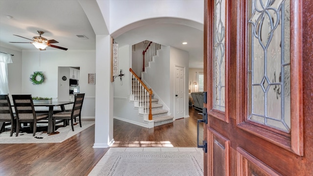 20703 Emerald Spruce Ct, Kingwood, TX 77346 - tiled foyer featuring ceiling fan, arched walkways, stairway, baseboards, and crown molding