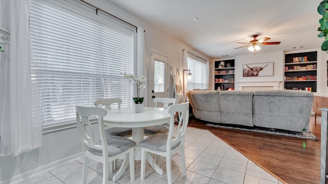 20703 Emerald Spruce Ct, Kingwood, TX 77346 - dining space with light tile patterned floors, ceiling fan, built in shelves, and baseboards