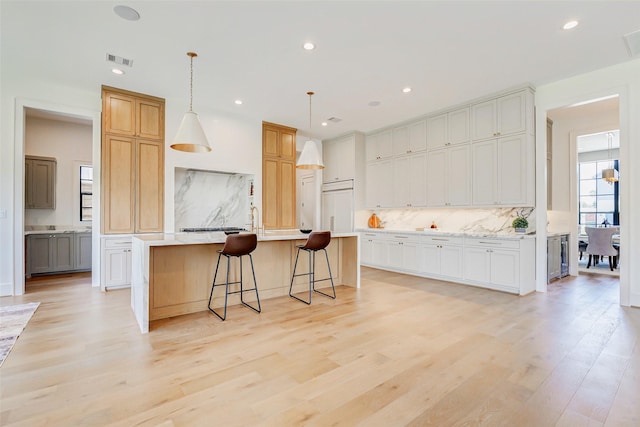 1810 Woodcrest Dr, Houston, TX 77018 - kitchen with backsplash, an island with sink, recessed lighting, light countertops, and light wood-style flooring