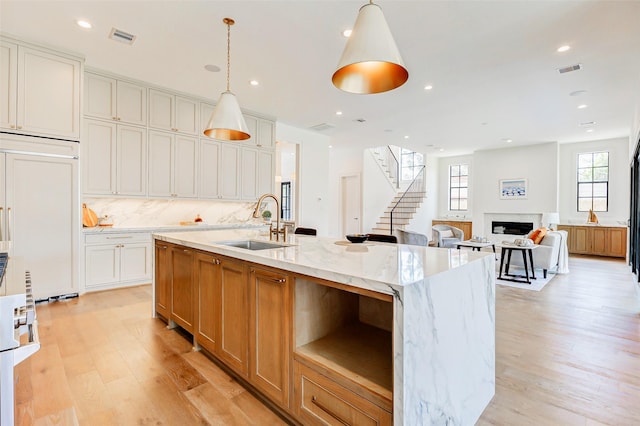 1810 Woodcrest Dr, Houston, TX 77018 - kitchen featuring a sink, light wood-style floors, a fireplace, decorative backsplash, and recessed lighting