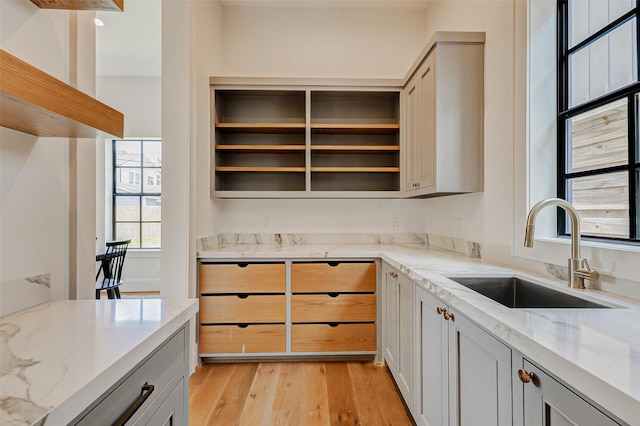 1810 Woodcrest Dr, Houston, TX 77018 - kitchen featuring a sink, open shelves, light stone countertops, and light wood-style flooring