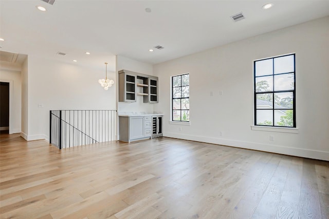 1810 Woodcrest Dr, Houston, TX 77018 - unfurnished living room featuring light wood-style flooring, baseboards, attic access, recessed lighting, and beverage cooler