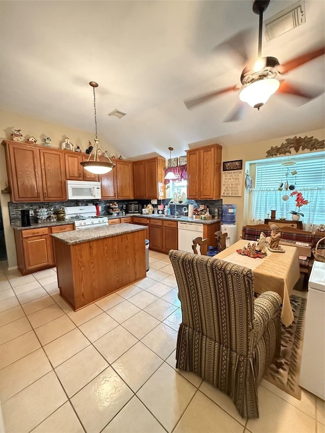 20122 Yellow Canyon Falls Dr, Tomball, TX 77375 - kitchen featuring white appliances, decorative backsplash, brown cabinetry, a kitchen island, and lofted ceiling