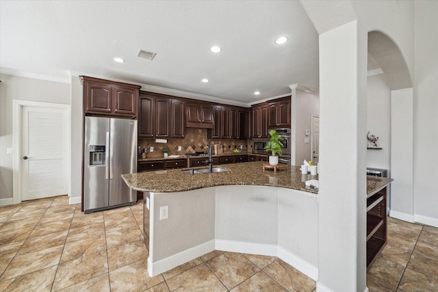 15718 Starcreek Ln, Houston, TX 77044 - kitchen featuring appliances with stainless steel finishes, crown molding, arched walkways, dark stone countertops, and dark brown cabinetry