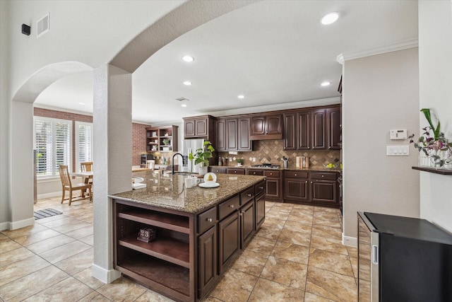 15718 Starcreek Ln, Houston, TX 77044 - kitchen with open shelves, baseboards, arched walkways, appliances with stainless steel finishes, and dark brown cabinets