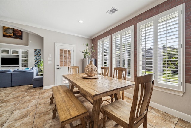 15718 Starcreek Ln, Houston, TX 77044 - dining area featuring ornamental molding, baseboards, arched walkways, light tile patterned flooring, and built in shelves