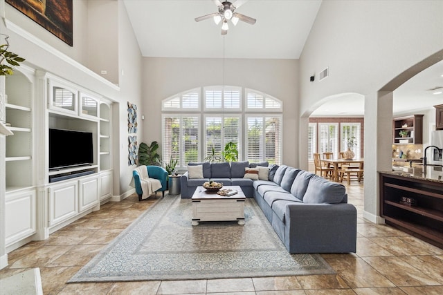 15718 Starcreek Ln, Houston, TX 77044 - living area featuring high vaulted ceiling, ceiling fan, built in shelves, arched walkways, and baseboards