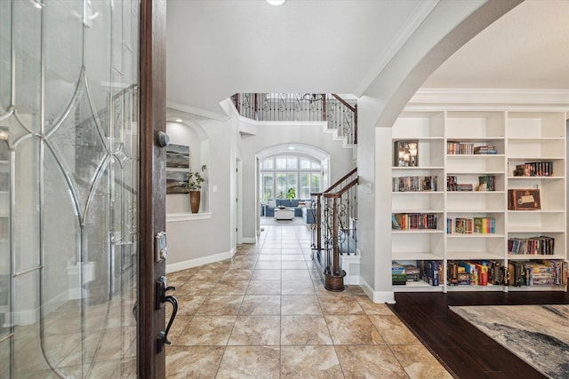 15718 Starcreek Ln, Houston, TX 77044 - entryway featuring ornamental molding, arched walkways, stairs, and baseboards