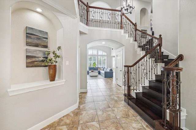 15718 Starcreek Ln, Houston, TX 77044 - foyer entrance featuring arched walkways, stairway, baseboards, a chandelier, and a high ceiling