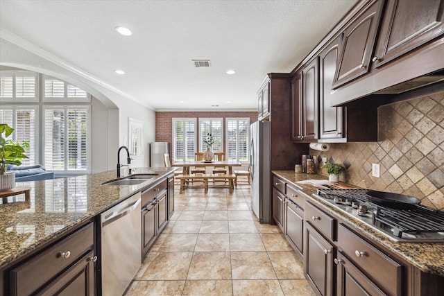 15718 Starcreek Ln, Houston, TX 77044 - kitchen featuring appliances with stainless steel finishes, a sink, dark brown cabinetry, tasteful backsplash, and ornamental molding