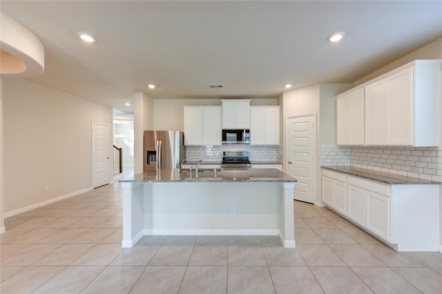 6531 Cody Mountain Trl, Richmond, TX 77407 - kitchen with appliances with stainless steel finishes, light tile patterned floors, backsplash, an island with sink, and recessed lighting