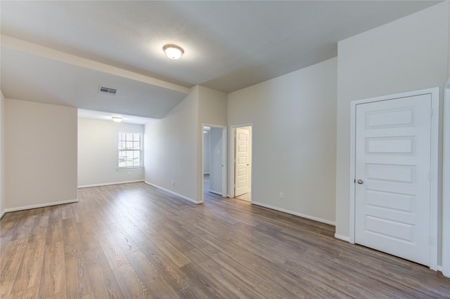 6531 Cody Mountain Trl, Richmond, TX 77407 - spare room with baseboards, wood finished floors, and lofted ceiling