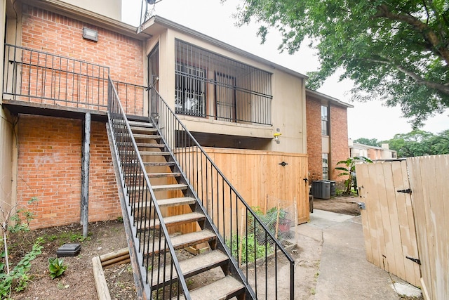 10100 S Gessner Rd Unit 308, Houston, TX 77071 - back of house with stairs, brick siding, and central AC