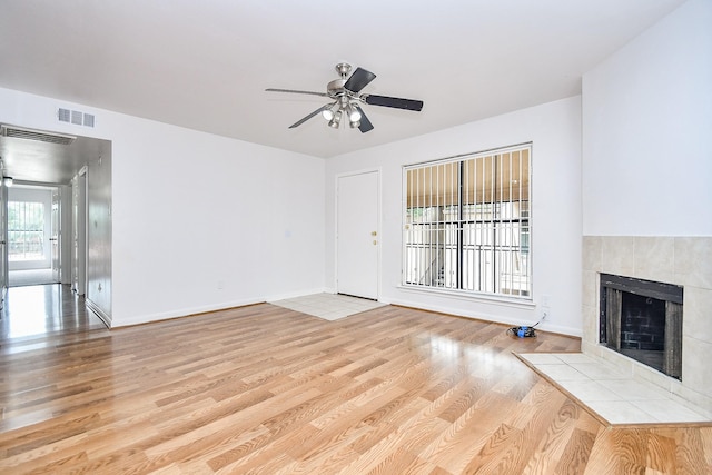 10100 S Gessner Rd Unit 308, Houston, TX 77071 - unfurnished living room featuring a ceiling fan, wood finished floors, a tile fireplace, and baseboards