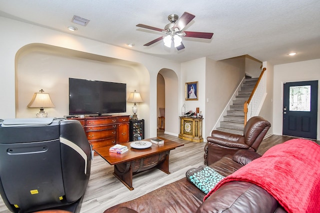 2206 Rocky Hollow Ln, Katy, TX 77450 - living room with arched walkways, ceiling fan, stairs, wood finished floors, and baseboards