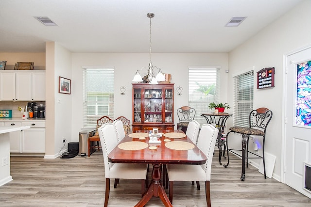 2206 Rocky Hollow Ln, Katy, TX 77450 - dining room featuring light wood finished floors, a chandelier, and baseboards