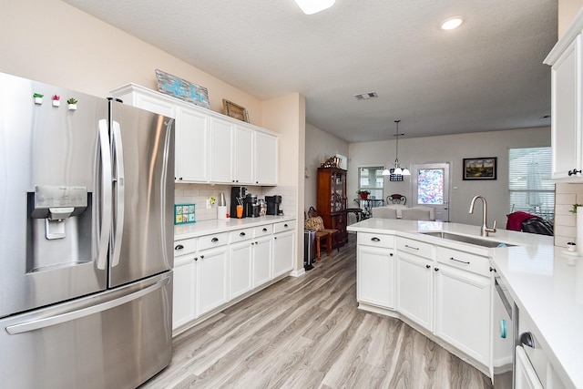 2206 Rocky Hollow Ln, Katy, TX 77450 - kitchen with stainless steel refrigerator with ice dispenser, a sink, light countertops, a peninsula, and backsplash