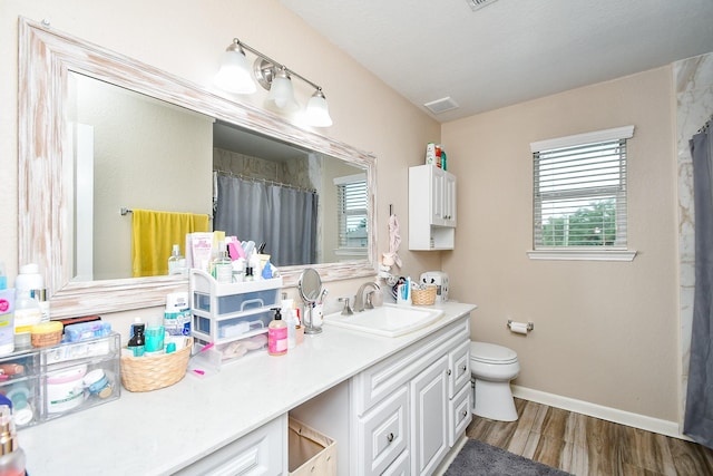 2206 Rocky Hollow Ln, Katy, TX 77450 - bathroom featuring toilet, vanity, wood finished floors, baseboards, and curtained shower