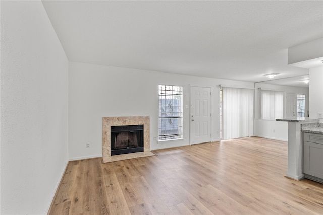 6500 Sands Point Dr Unit 107, Houston, TX 77074 - unfurnished living room with light wood finished floors, a fireplace, and baseboards