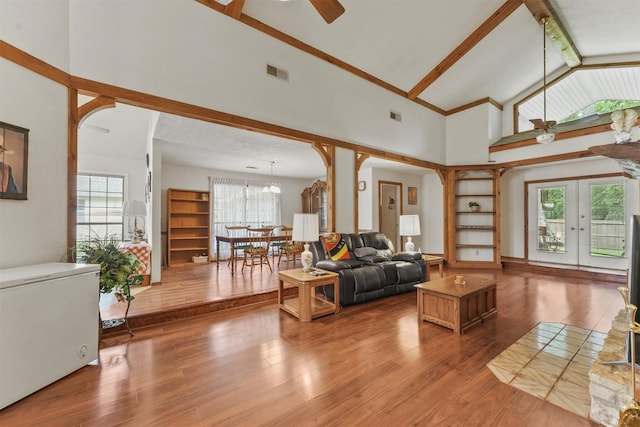 103 Whippoorwill Dr, Livingston, TX 77351 - living room featuring arched walkways, high vaulted ceiling, wood finished floors, plenty of natural light, and beamed ceiling