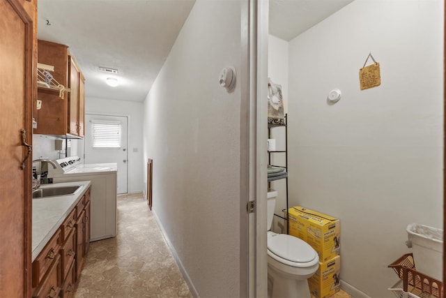 103 Whippoorwill Dr, Livingston, TX 77351 - bathroom with washer and clothes dryer, toilet, vanity, baseboards, and stone finish floors